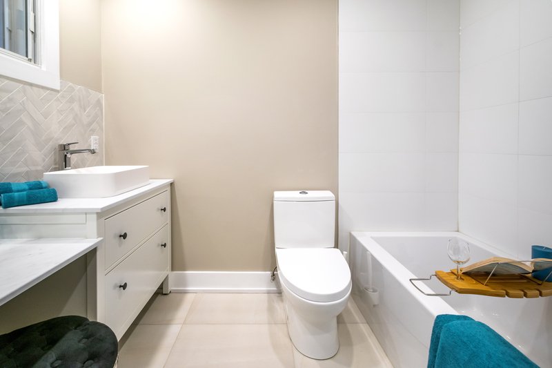 baño de casa en venta en Puebla con acabados en blanco y pared beige.